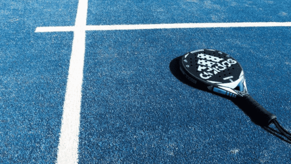 Padelracket op blauw kunstgras