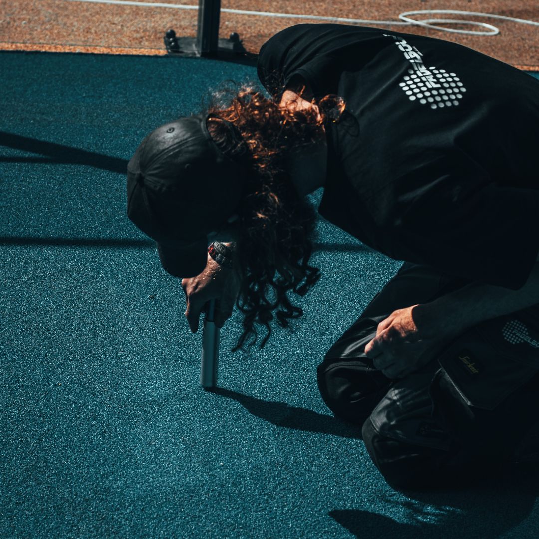 Onderhoudsspecialist die het kunstgras inspecteert